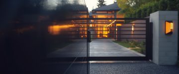 Close-up of a modern electric driveway gate outside a residential home in Portland, Oregon, with sleek metal panels and smooth automation details.